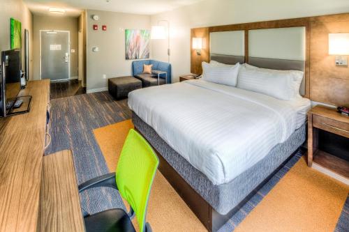 韦斯特莱克Holiday Inn Express & Suites Cleveland/Westlake, an IHG Hotel的酒店客房带一张大床和一把椅子