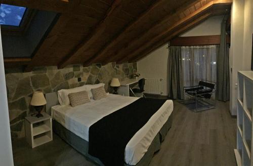 索拉雷斯Hosteria La Moraleja的一间卧室设有一张大床和石墙