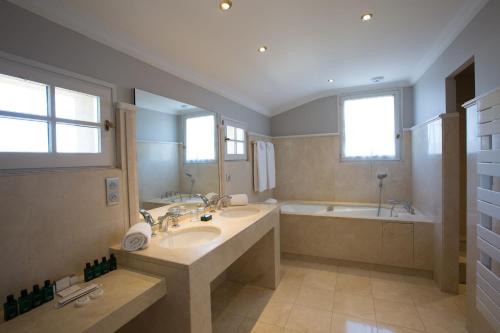 阿维尼翁欧洲酒店的浴室配有2个盥洗盆、浴缸和浴缸。