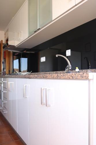 波尔图Apartamento Galerias的厨房配有白色橱柜和水槽