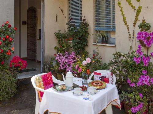 米罗La Ginestra casa vacanze的花卉茶具上的白色桌子