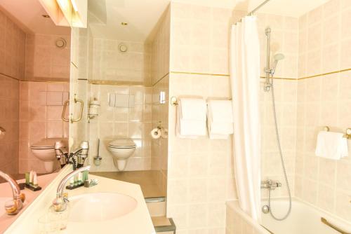 滨海卡特韦克北海酒店的一间带水槽、淋浴和卫生间的浴室