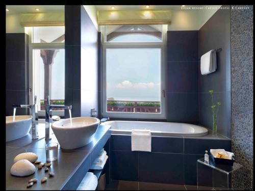埃维昂莱班厄尔米塔奇酒店的一间带大浴缸和大窗户的浴室