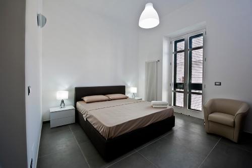 莱切La Casa delle Zie的卧室配有床、椅子和窗户。
