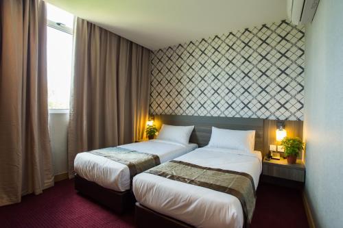 新山LS酒店的酒店客房设有两张床和窗户。