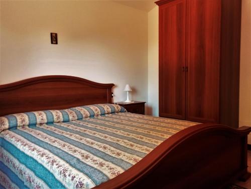 圣安蒂奥科Pineta Spiaggia Grande的一间卧室配有一张床和一个木制橱柜