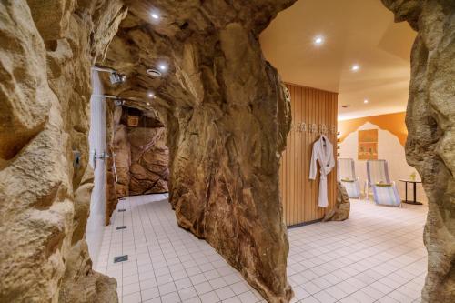 克林根塔尔沃格兰瓦尔德酒店的一间带大型岩石墙的浴室