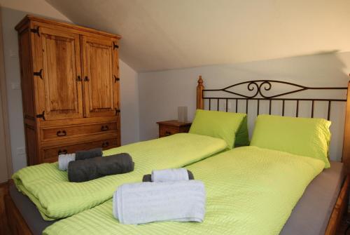 施库尔Feriendorf Uorsin的一间卧室配有两张床,铺有石灰绿色床单