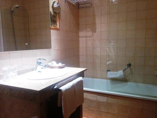 维赫恩-瓦拉加贝桑安杜哈尔山酒店的浴室配有盥洗盆、浴缸和盥洗盆
