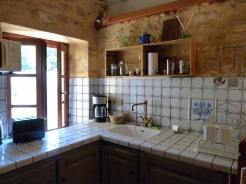 维特拉克Charmante Maison Troglodyte的厨房配有水槽和台面