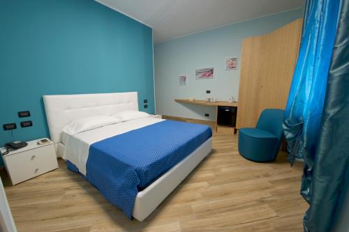 泰拉奇纳Relais Piazza Garibaldi的蓝色卧室配有一张床和一张书桌