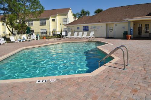 基西米拉古纳湾别墅公寓的一个带椅子的庭院和房子的游泳池