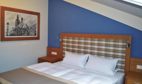 HettstedtHotel & Restaurant Waldcafe Hettstedt的一间卧室配有一张蓝色墙壁的床