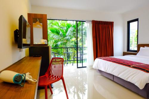 卡马拉海滩The Umbrella House - SHA Extra Plus的一间卧室配有一张床、一张书桌和一个窗户。