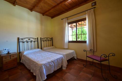 埃尔帕索Casas Rurales Tola的一间卧室设有两张床和窗户。