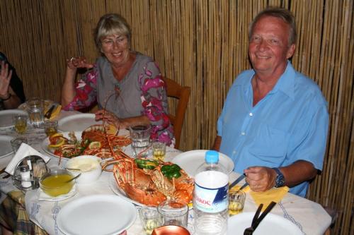 阿吉亚利阿斯卡斯酒店的男人和女人坐在桌子上,带着螃蟹