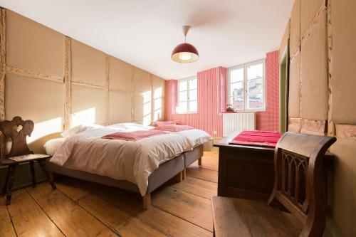 科尔马Les Appartements Saint Nicolas的一间卧室设有一张大床,铺有木地板