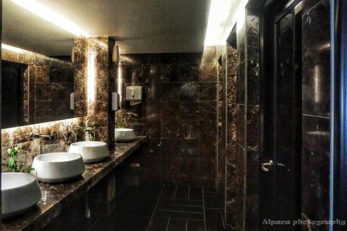新山柔佛州新山内克斯酒店的一间带三个盥洗盆和淋浴的浴室