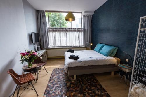 阿姆斯特丹阿姆斯特丹之家工艺品酒店的一间卧室配有一张蓝色墙壁的床