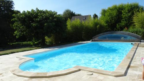 AnchéMoulin de reigner的一座大游泳池,位于一个树木繁茂的庭院内
