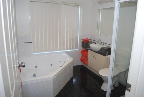 莱克斯恩特伦斯卢考特假日公寓的带浴缸、卫生间和盥洗盆的浴室
