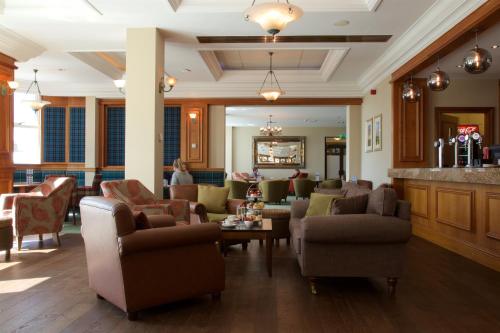 卡诺斯蒂卡诺斯蒂高尔夫“定制酒店“的带沙发和椅子的大堂以及酒吧