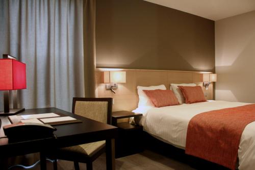 Genappe皇帝旅馆的配有一张床和一张书桌的酒店客房