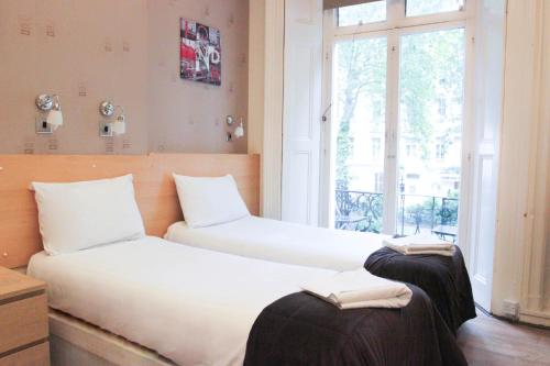 伦敦托尼之家酒店的带窗户的客房内设有两张单人床。