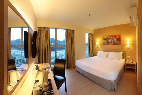 吉隆坡明科特酒店的酒店客房设有一张床、一张书桌和窗户。