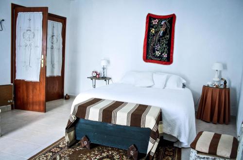 莫朗Os 5 Sentidos的卧室配有一张白色的大床和一扇门