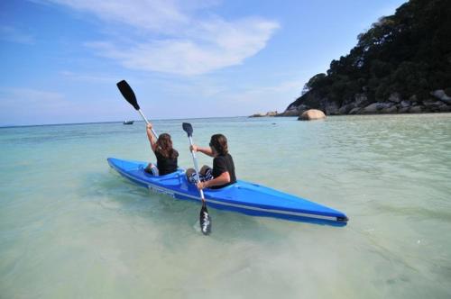 停泊岛弗洛拉湾1号酒店的两个女人坐在水上的蓝色皮艇上