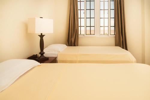 乔治敦Hampton Apartments Guyana的一间卧室设有两张床和窗户。