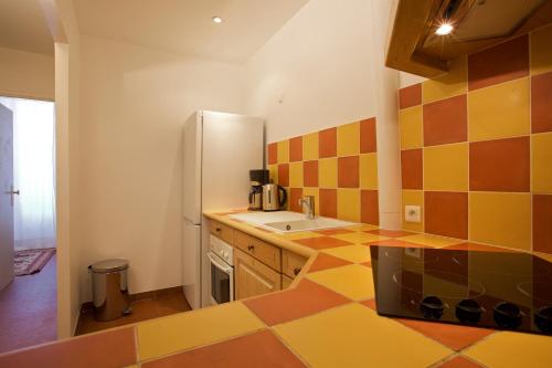 昂蒂布马塞纳街15号公寓的厨房铺有色彩缤纷的瓷砖地板,配有冰箱。