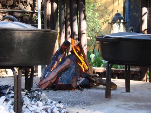 布隆方丹杰迪德加住宿加早餐旅馆的女人在烤架上的火上做饭
