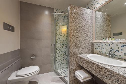 西尔米奥奈伊登酒店的浴室配有卫生间、盥洗盆和淋浴。