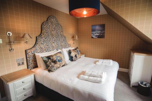 塔伯特Kirklea Island Suites的一间卧室配有一张大床和两条毛巾
