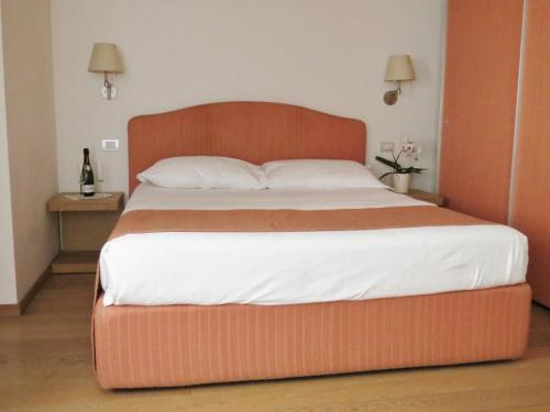 米兰贝利萨里奥费拉米兰诺公寓的卧室内的一张大床和一张大型木制床头板