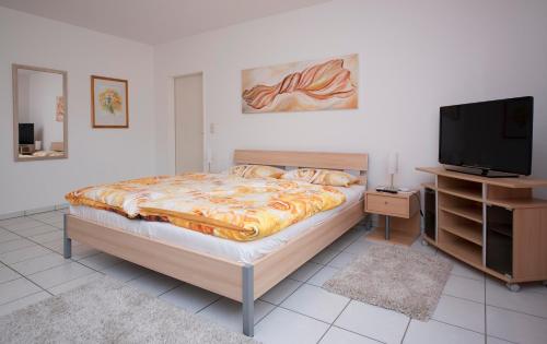 NiedermennigHaus Elfriede的一间卧室配有一张床和一台平面电视