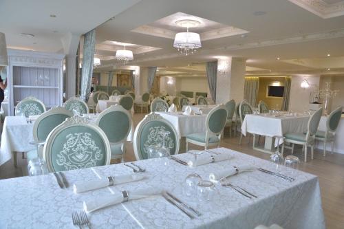 基希讷乌布里斯托尔中央公园酒店的一间设有白色桌椅的用餐室