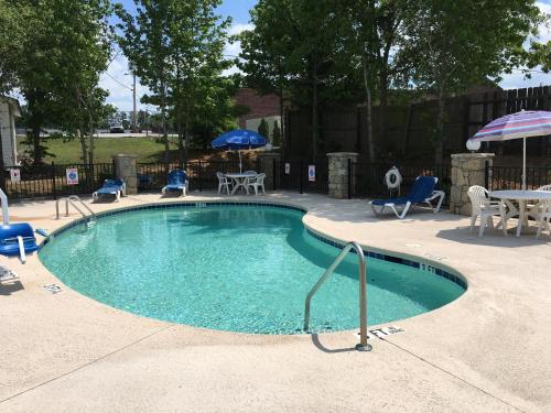 科尼尔斯科尼尔斯美国最佳价值酒店的游泳池配有椅子、桌子和遮阳伞