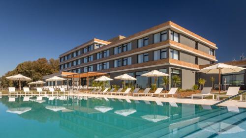阿尔米隆温泉Salinas del Almiron Resort Termal的大楼前设有游泳池的酒店