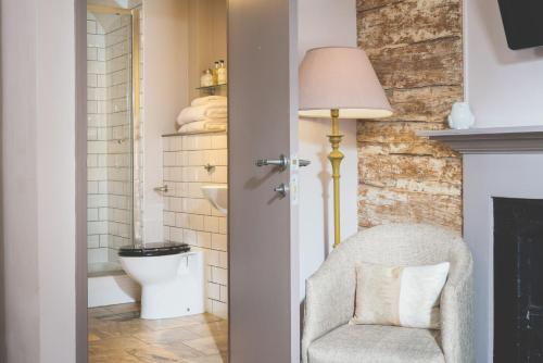 埃克塞特全球酒店的一间带椅子和卫生间的浴室