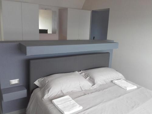 卡尼洛瑞维拉Appartamento Wow的床上有2个白色枕头,上面有架子
