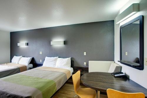 斯威特沃特Studio 6-Sweetwater, TX的酒店客房设有两张床和一张桌子。