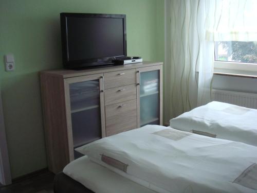 勒斯拉特Ferien- Messewohnung nähe Köln-Messe Flughafen Bonn的一间卧室配有两张床,一个梳妆台上配有电视。