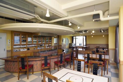 志摩市托比旅馆公寓的图书馆内带桌椅的用餐室