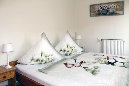 诺德代希Pension Nordsee的床上的2个枕头,上面有蝴蝶