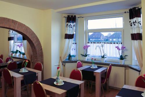 诺德代希Pension Nordsee的餐厅设有桌椅和窗户。