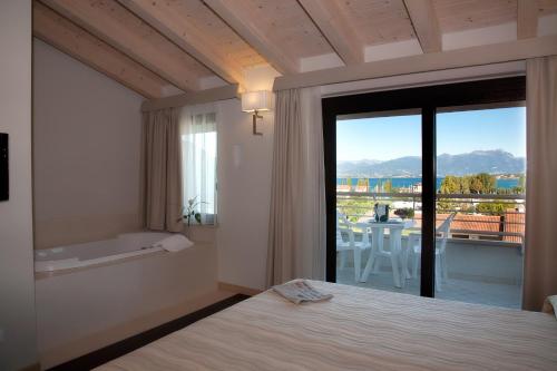 西尔米奥奈波尔图阿祖罗酒店的一间卧室设有一张床,享有阳台的景色