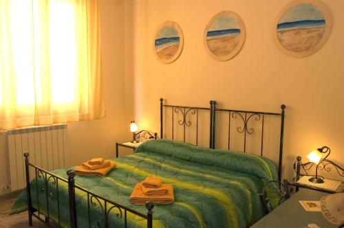 菲乌梅夫雷多迪西奇利亚太阳的色彩住宿加早餐旅馆的一间卧室配有绿床和2条毛巾
